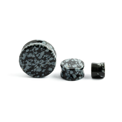 several sizes of double flare Snowflake Obsidian stone ear plugs front and side view
