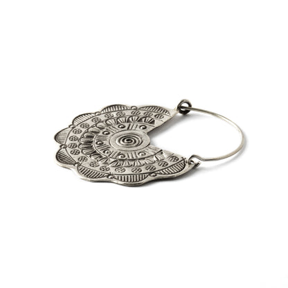 pair of flower disc silver earrings with tribal motifs stamps close up side view