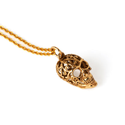 Bronze sugar skull charm on a chain above view