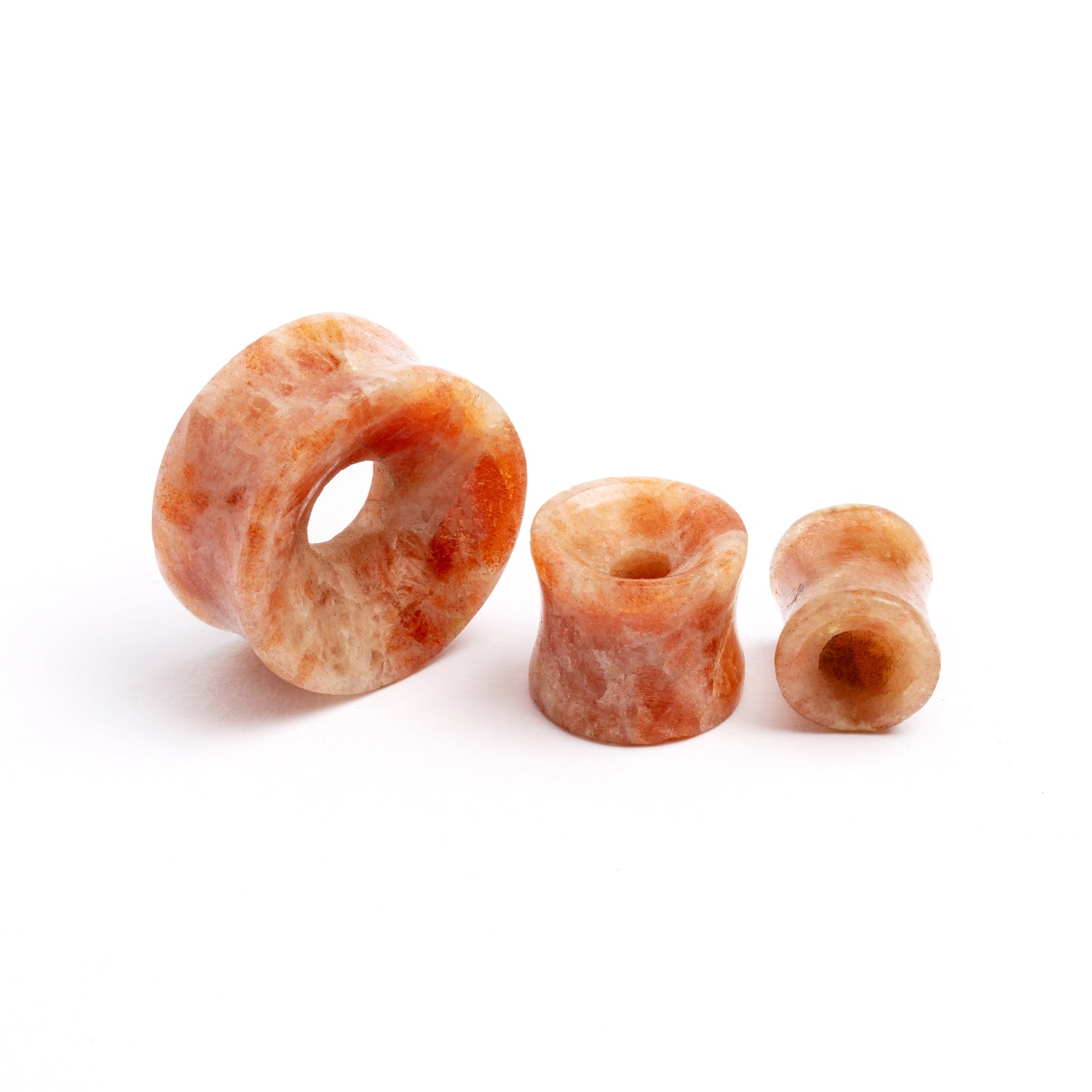 several sizes of Sunstone double flare stone ear tunnel front and side view