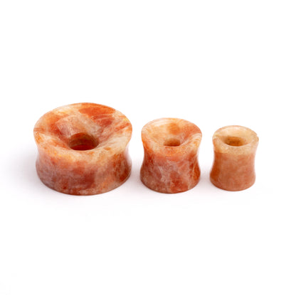 several sizes of Sunstone double flare stone ear tunnels side view