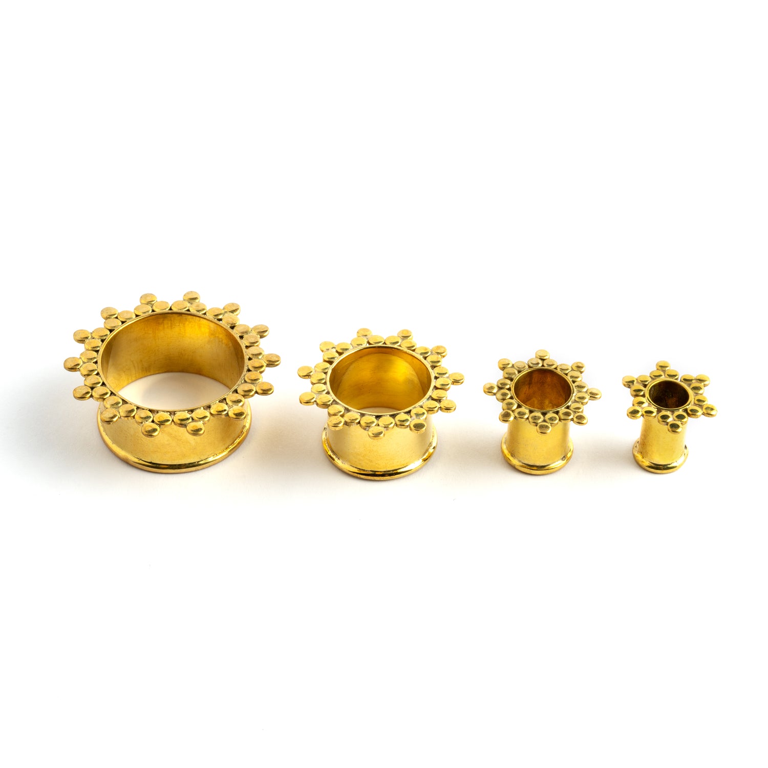 several sizes of golden brass spheres flower ear tunnels side view