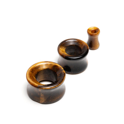 several sizes of Tiger Eye double flare stone ear tunnel s front view