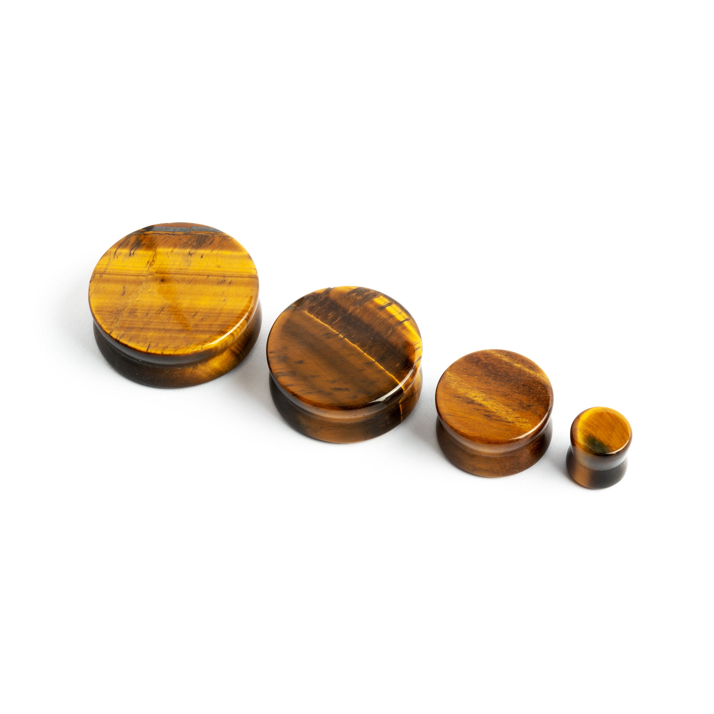 several sizes of tiger eye double flare stone ear plugs front view