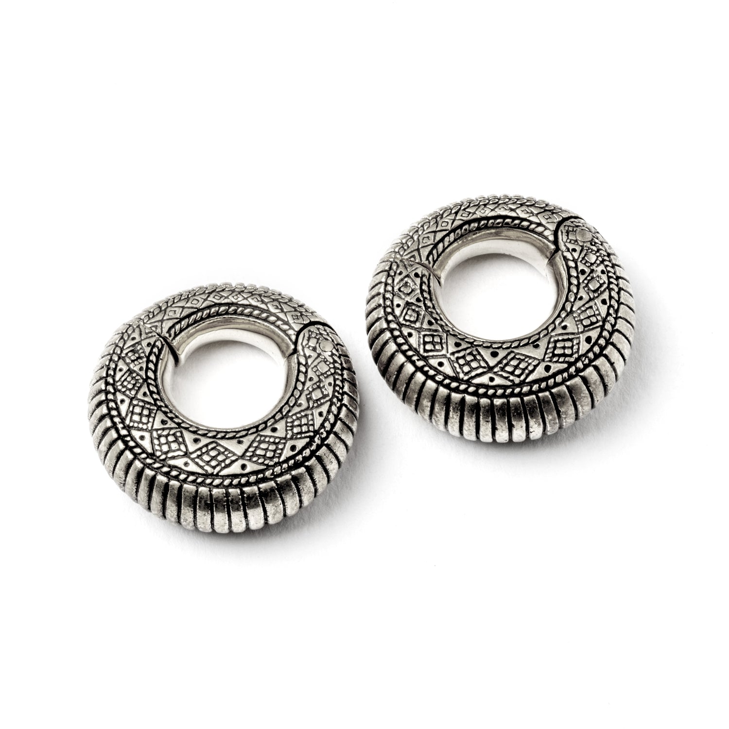pair of silver brass ear weights hoops with geometric tribal engraved pattern right frontal view