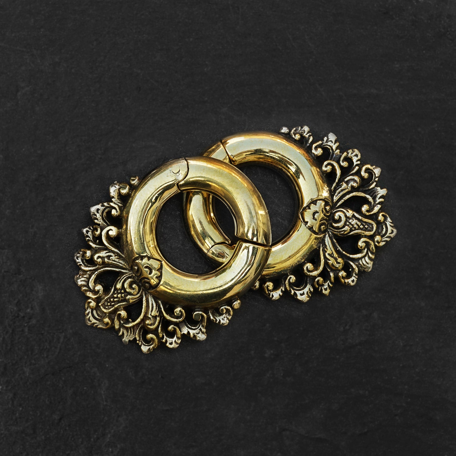 pair of gold brass ear hangers hoops with floral victorian design frontal view black background