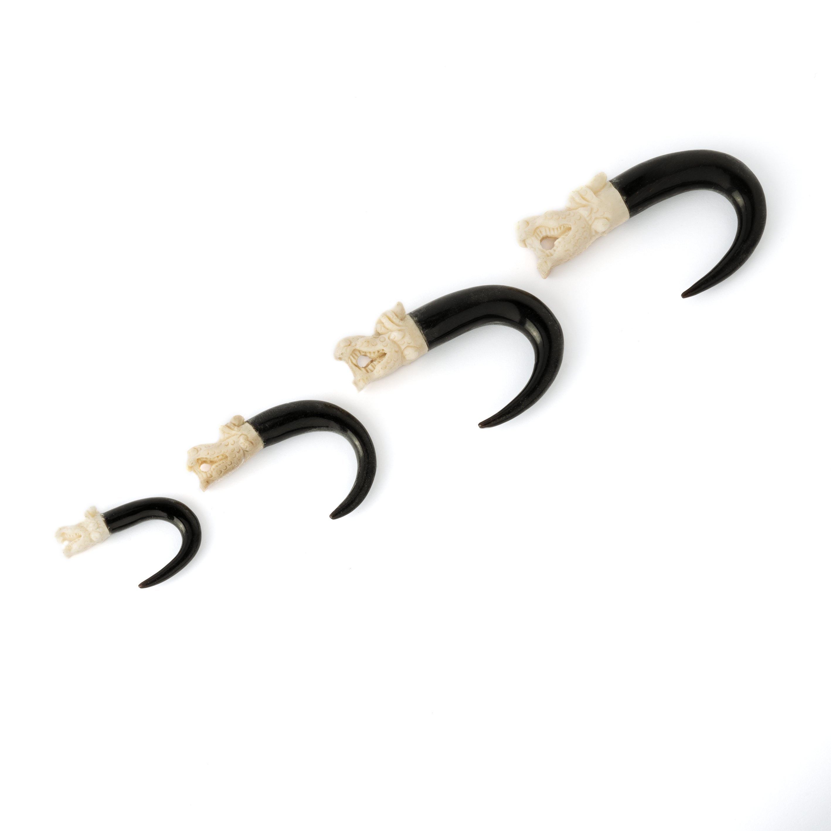 different sizes of White dragon head ear stretchers side view
