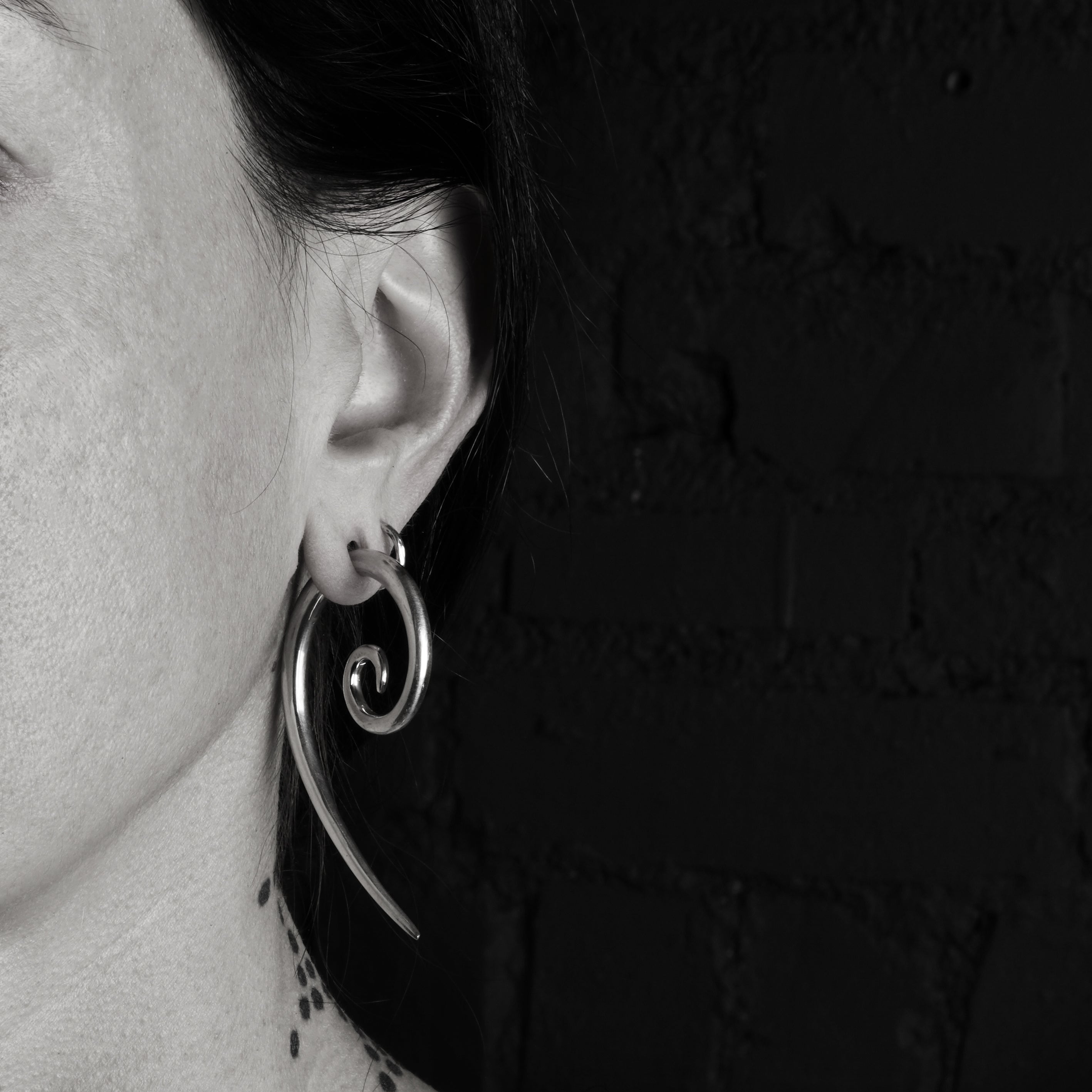 model wearing silver spiral long hook gauge earring