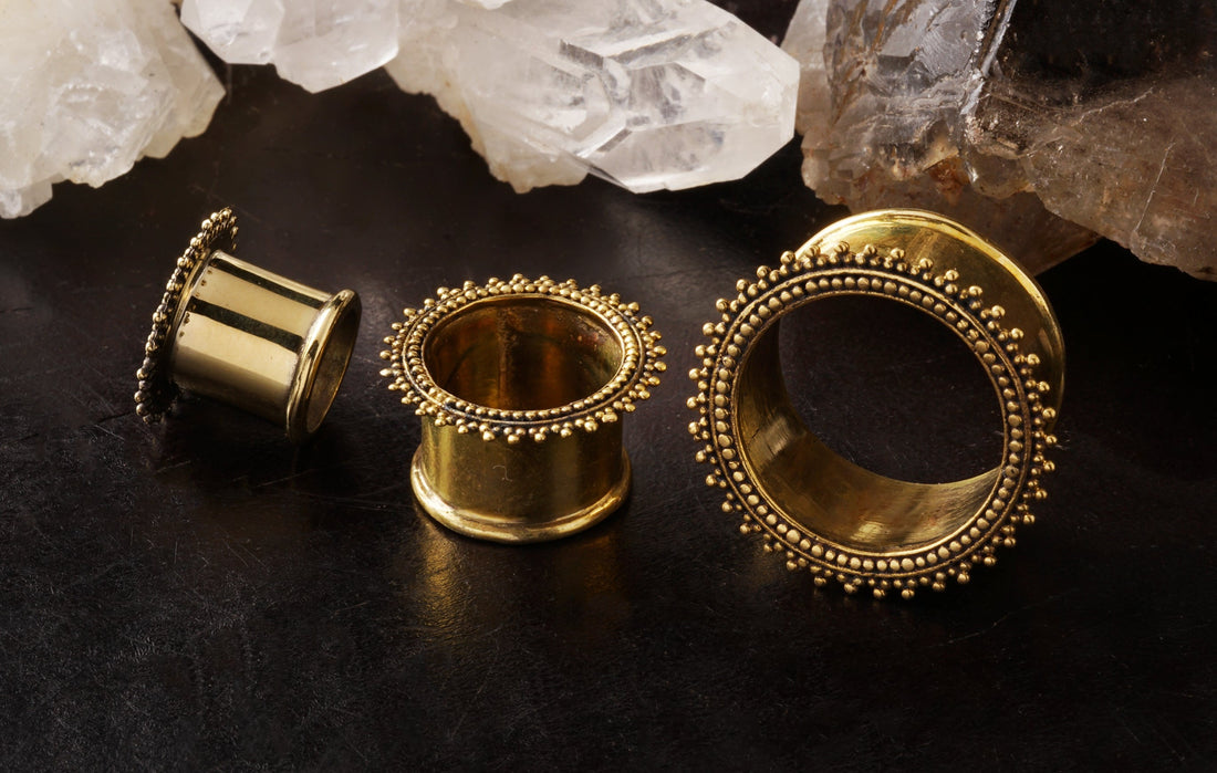 several sizes of golden brass Indian ear tunnel front and side view