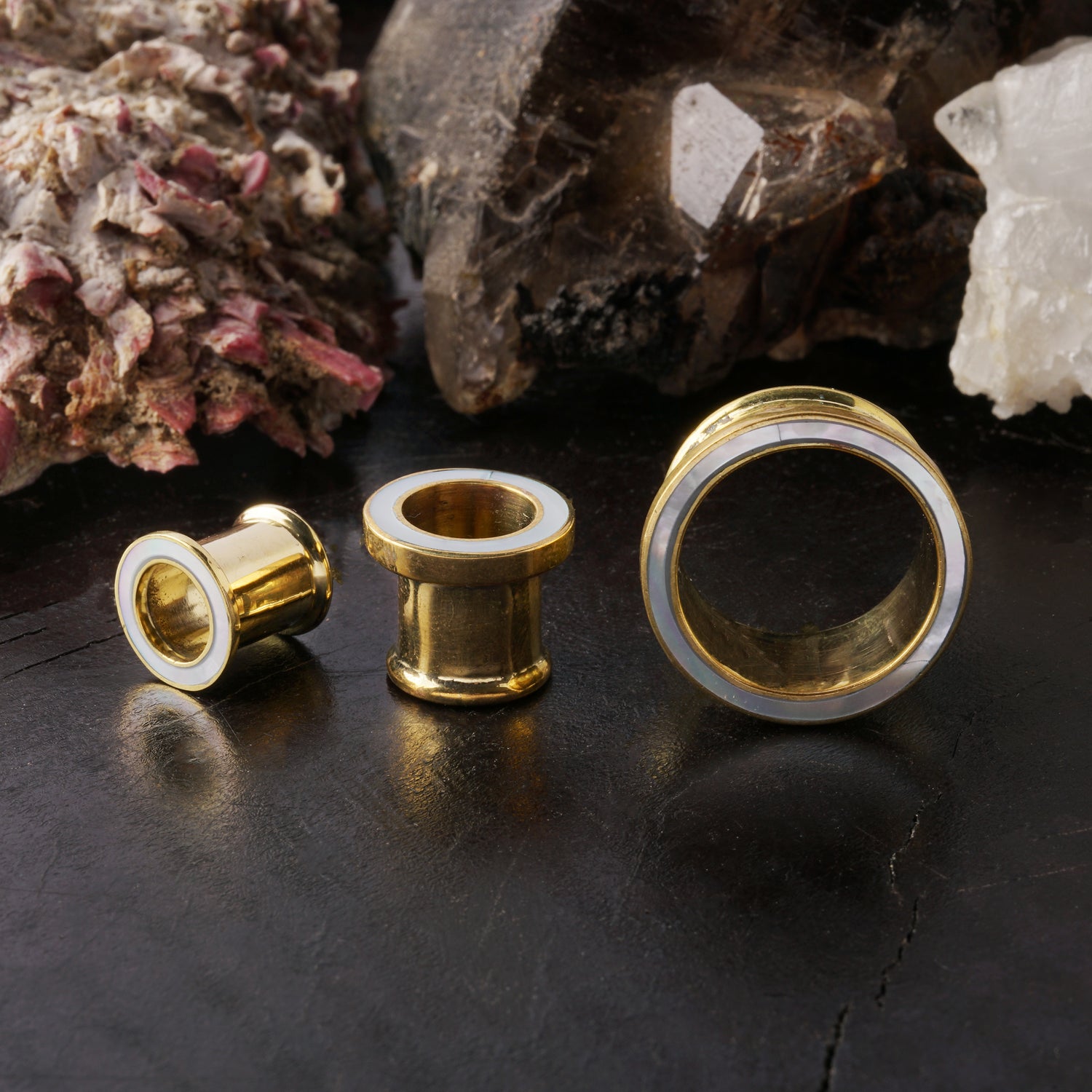 several sizes of golden brass with MOP ear tunnels front and side view