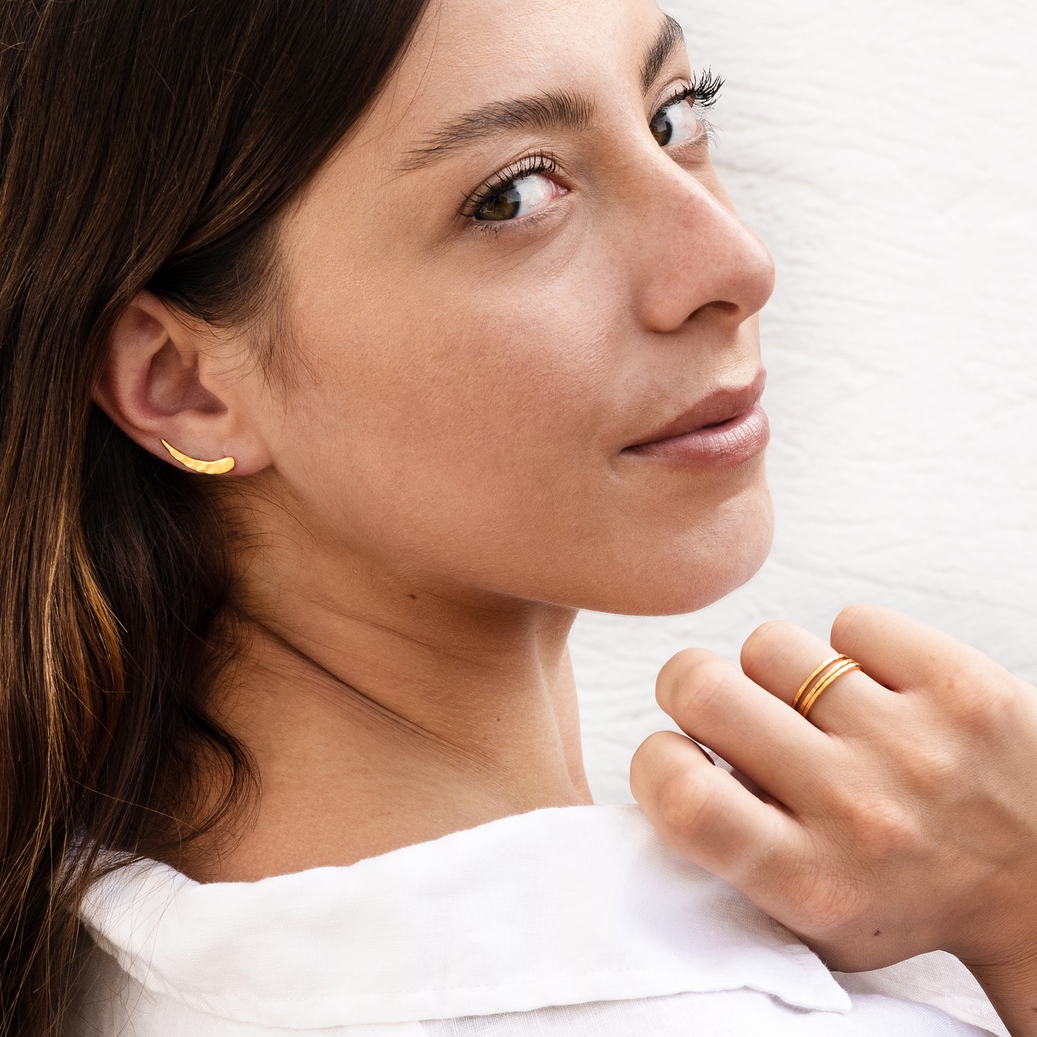model wearing multiple 24k gold hammered stacking band rings