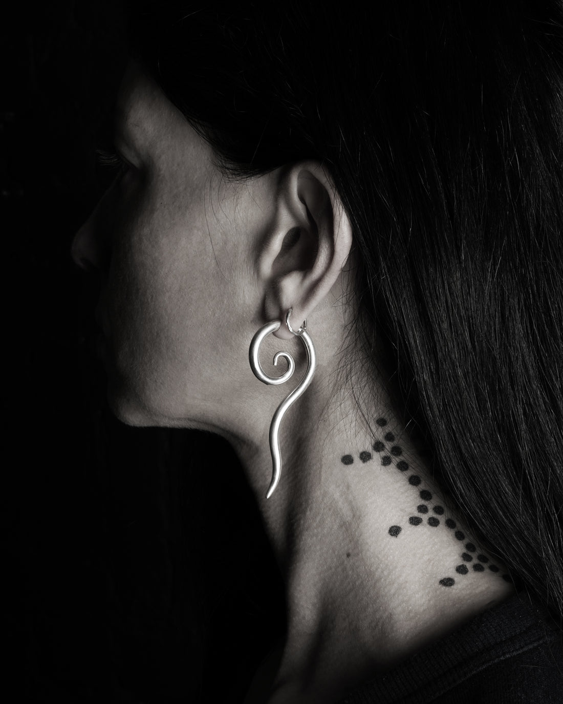 MODEL WEARING SINGLE SILVER LONG TAILED SPIRAL EAR STRETCHER HANGER