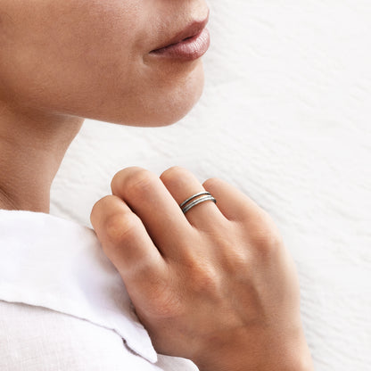 model wearing multiple hammered silver stacking band rings