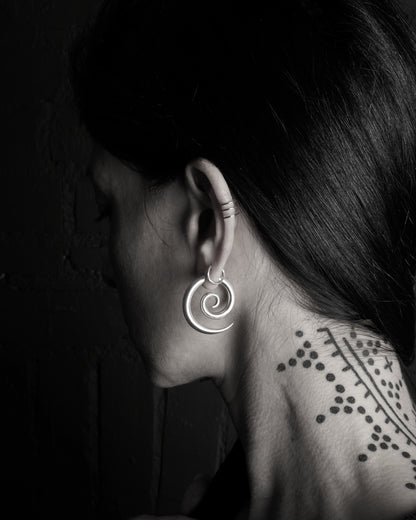 model wearing silver spiral gauge earring