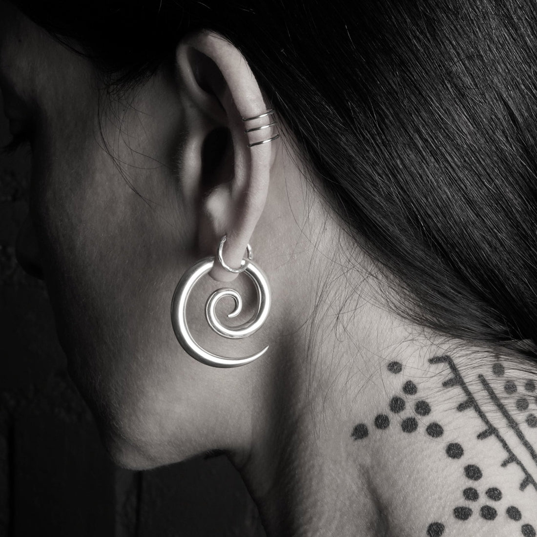 model wearing silver spiral gauge earring