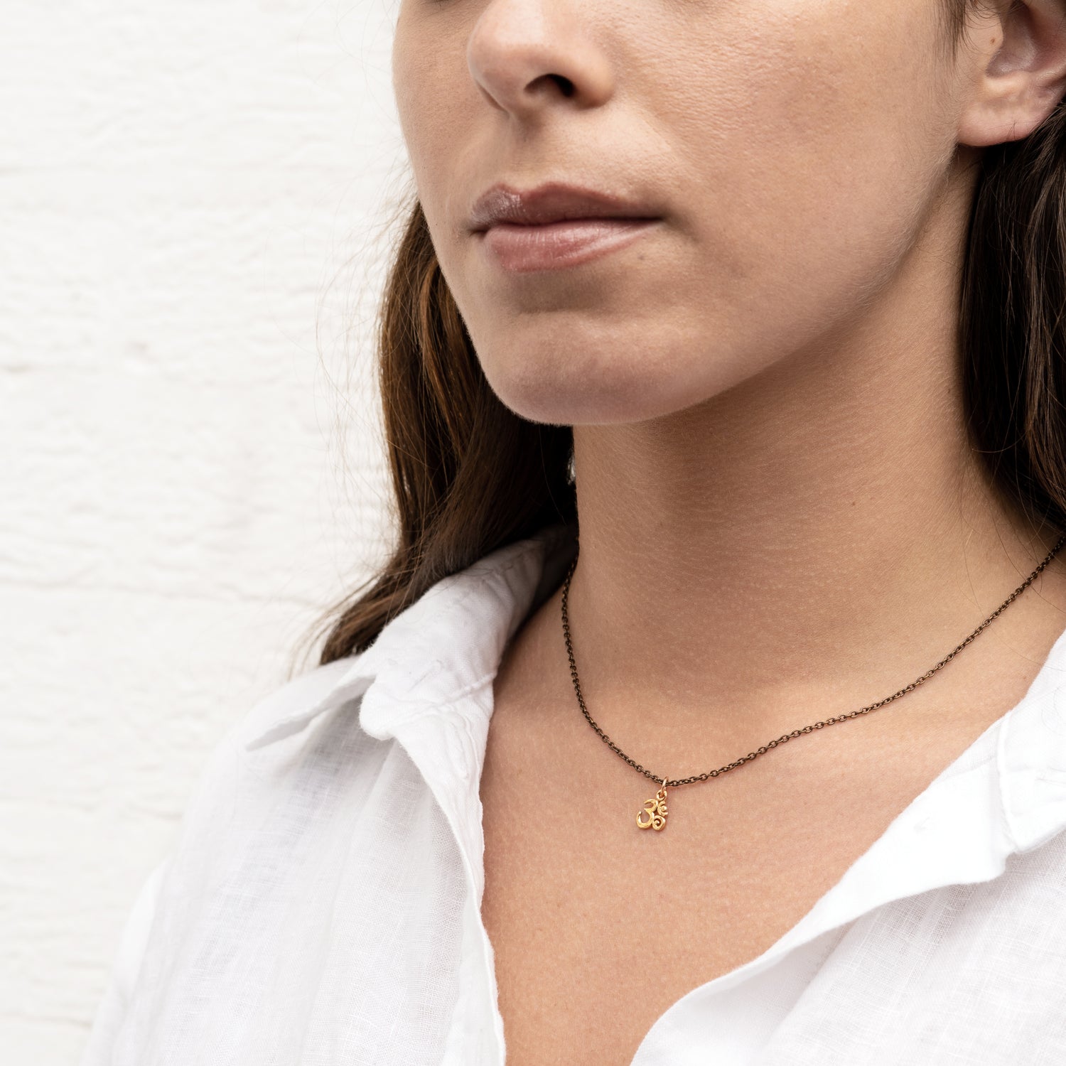 model wearing Bronze Petit Om Charm necklace